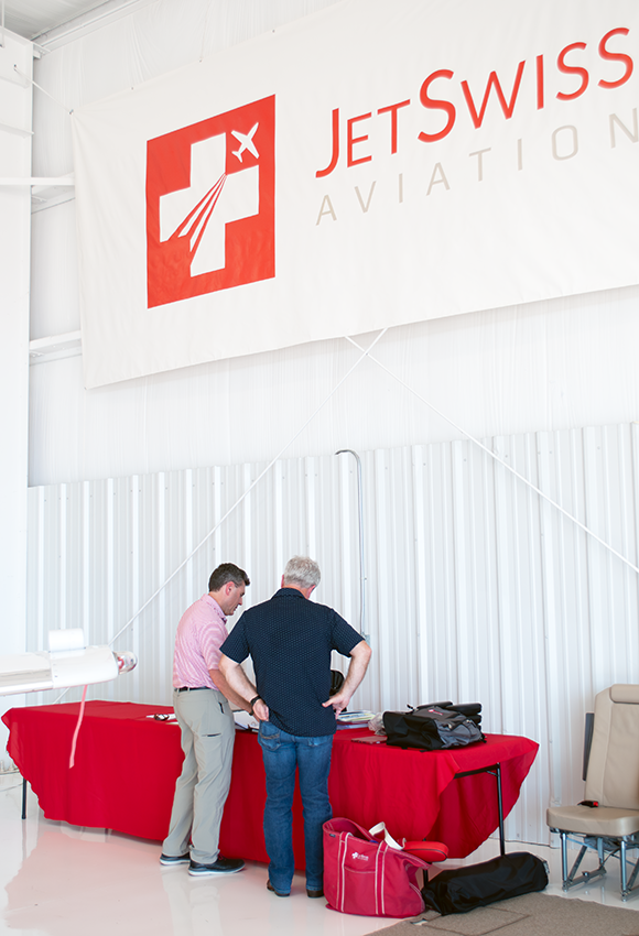 JetSwiss Aviation team reviewing aircraft records and logbooks in the hangar with client